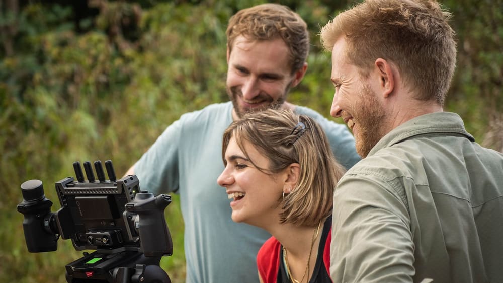 Sebastian and two filmmakers looking at a camera monitor on a shoot