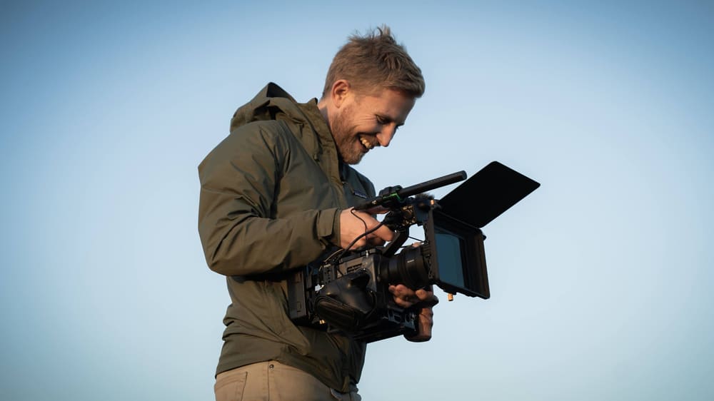 Sebastian filming with a camera on his shoulder