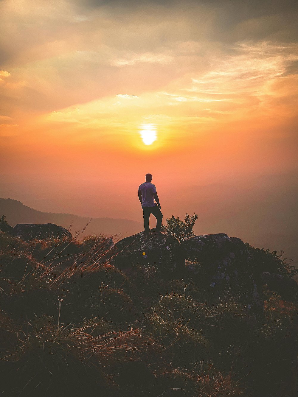 A man standing on a mountain at sunrise