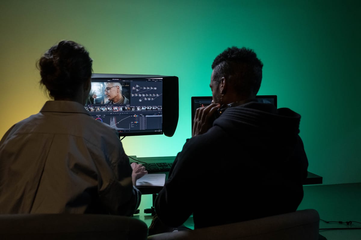 Documentary editor reviewing footage on a timeline in a dark editing suite