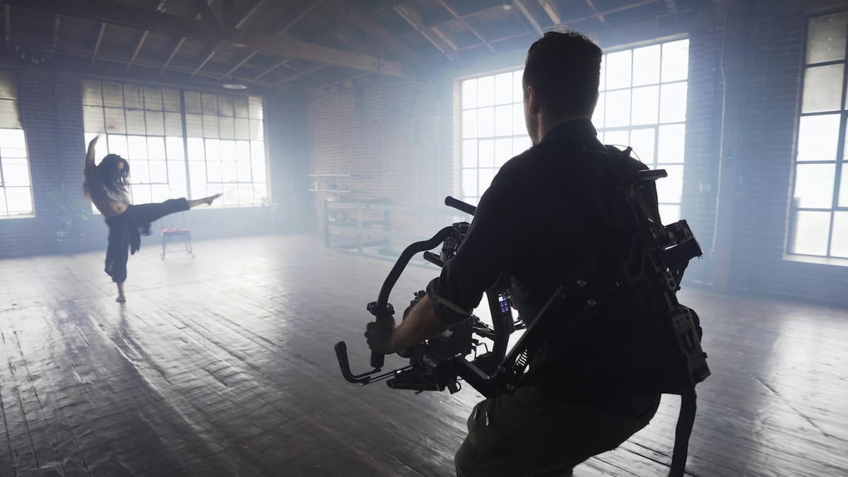 Filmmaker operating a gimbal on location for cinematic shots