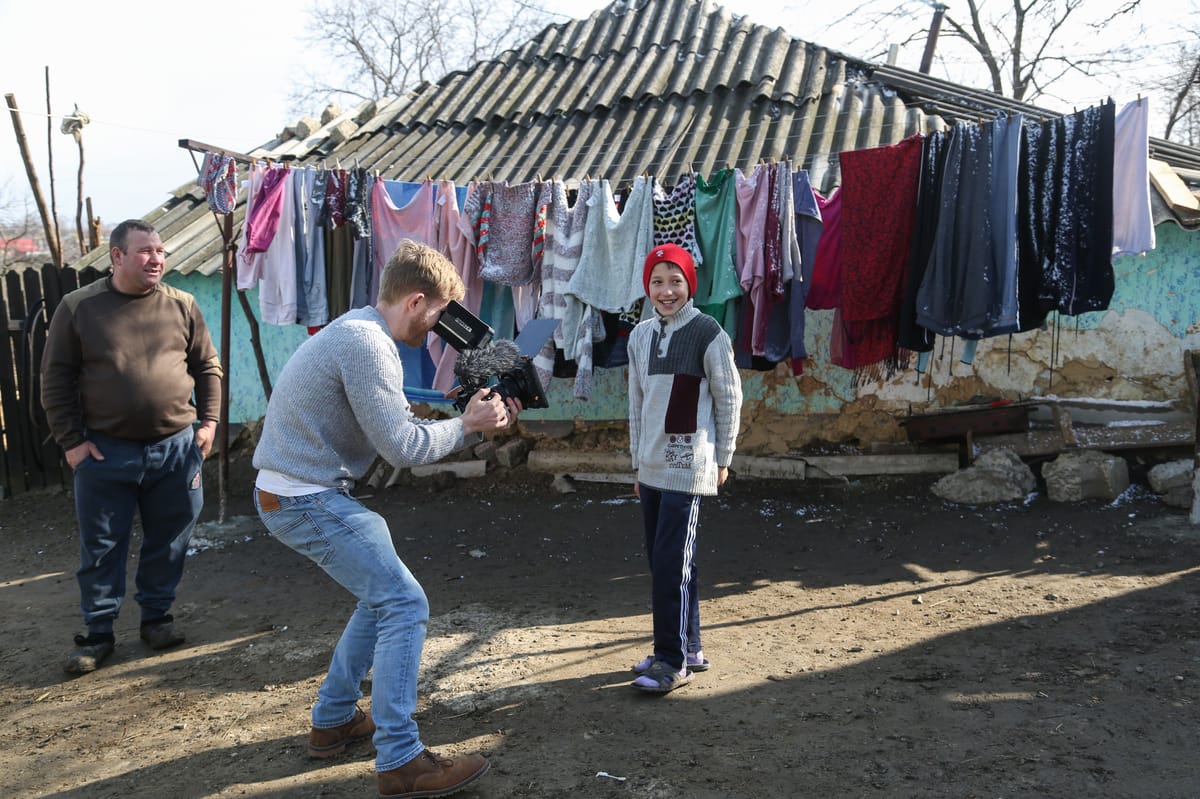 Documentary filmmaker reviewing footage with interview subject, demonstrating ethical storytelling practices