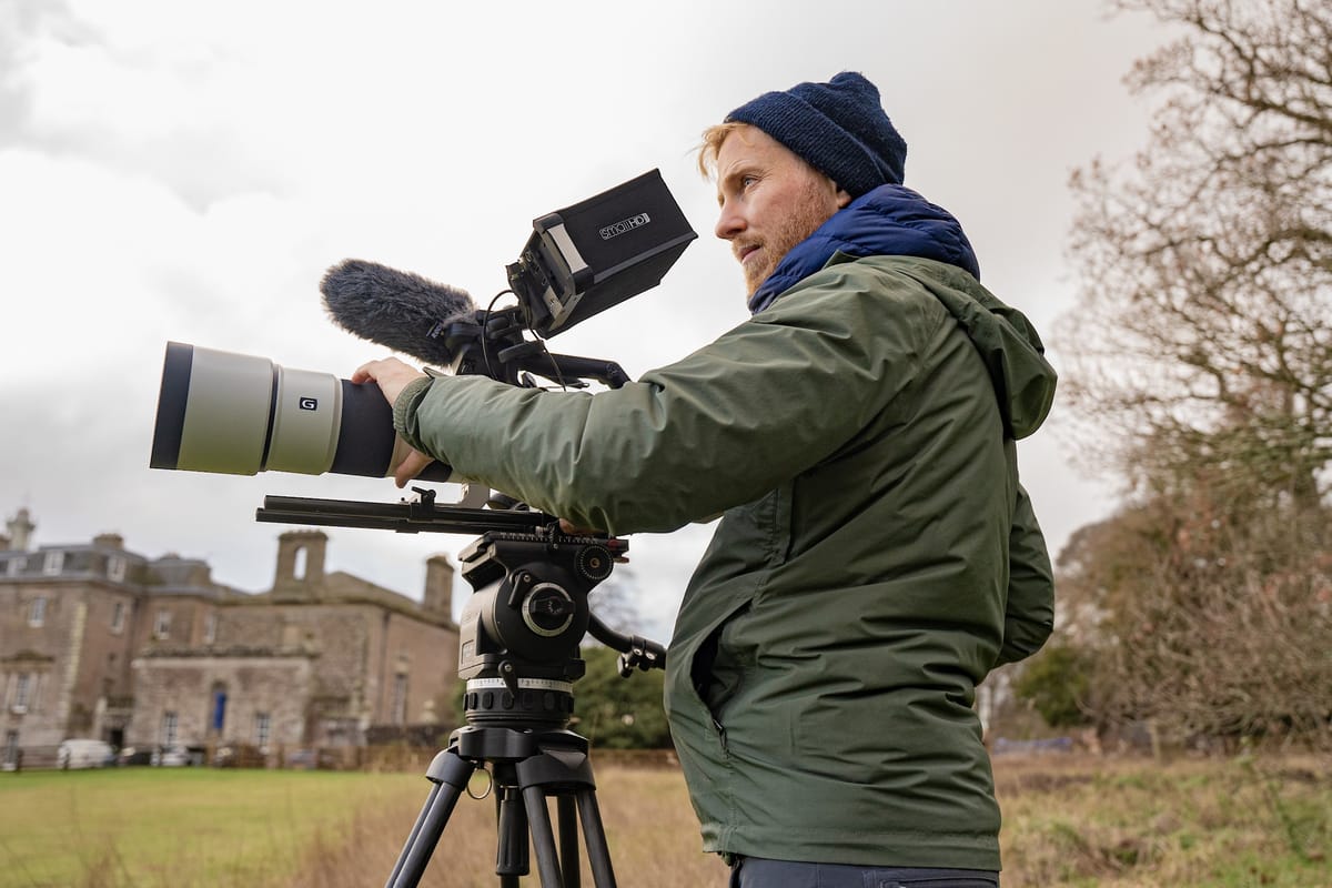 Solo filmmaker reviewing footage on location