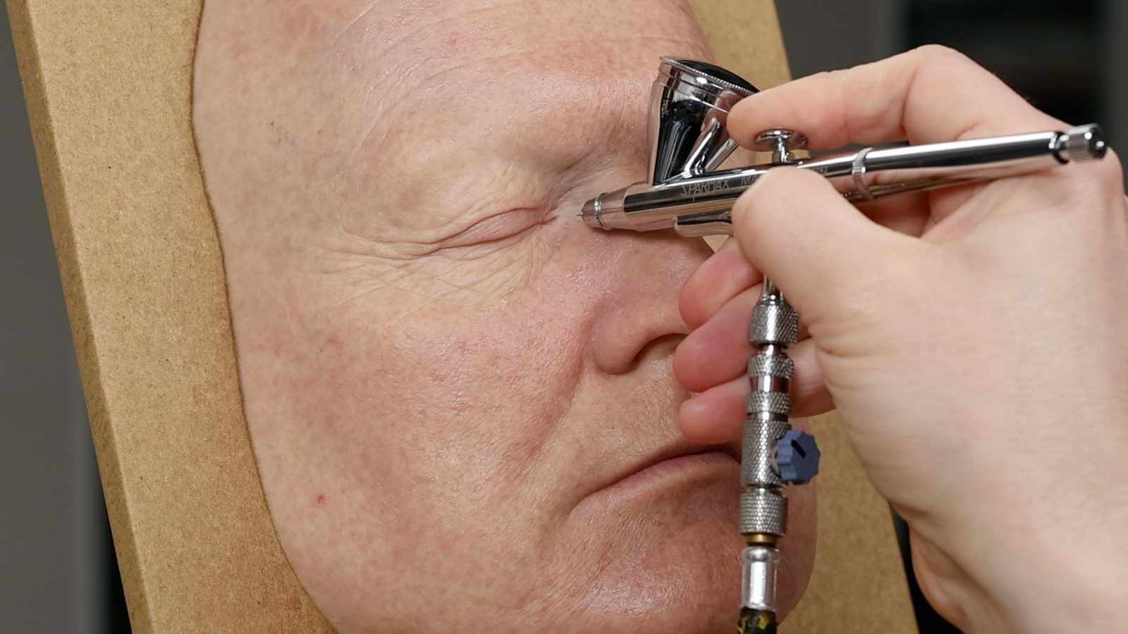 David Malinowski airbrushing realistic skin tones onto a silicone face with a Sparmax airbrush
