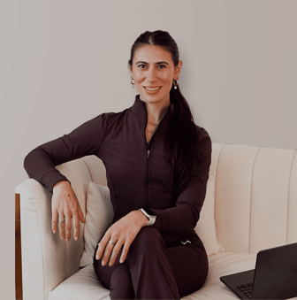 Gianna Cestone smiling on a cream armchair