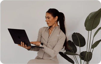 Gianna Cestone working on a laptop next to a large plant