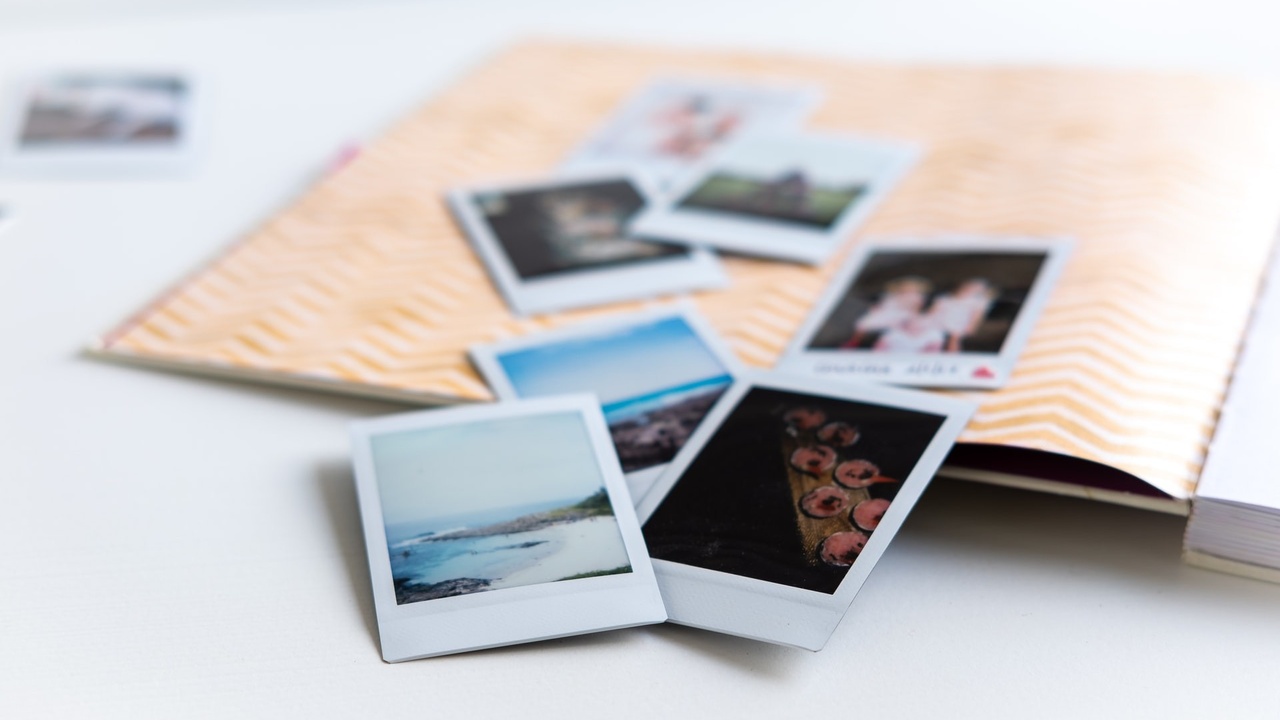 photos laying across a scrapbook page ways to save money on scrapbooking products