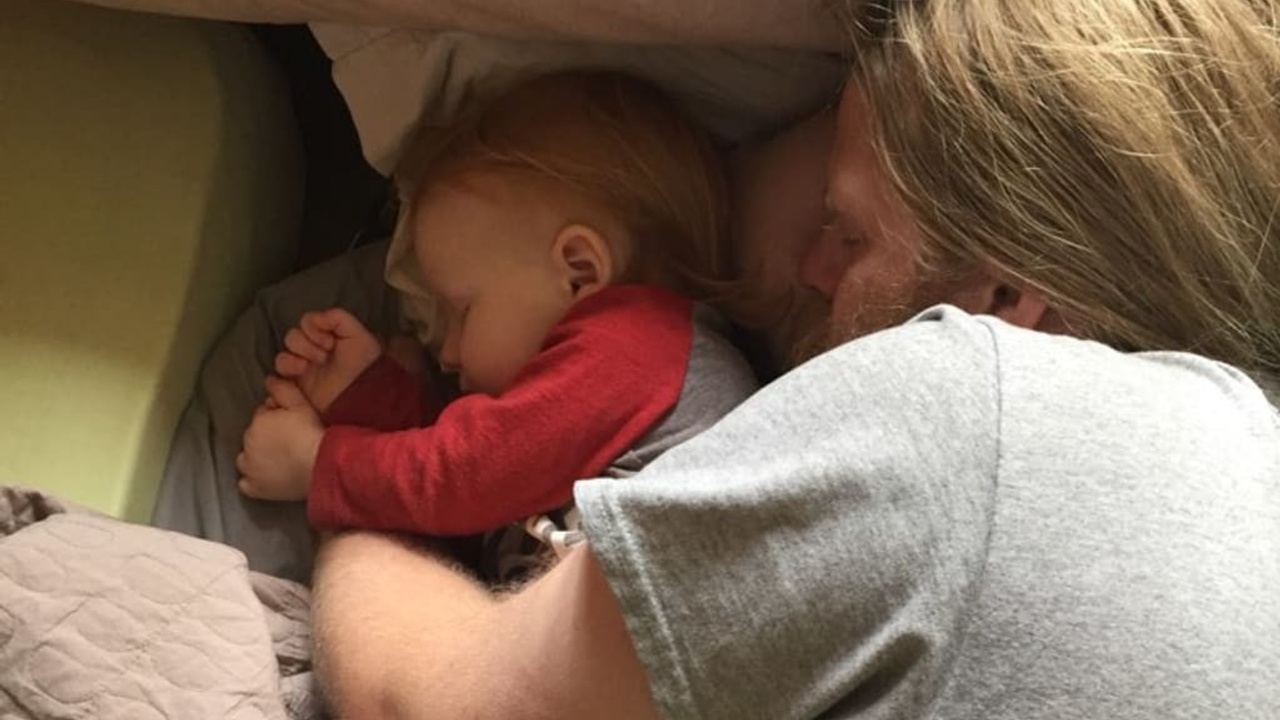 Father and child asleep on the floor