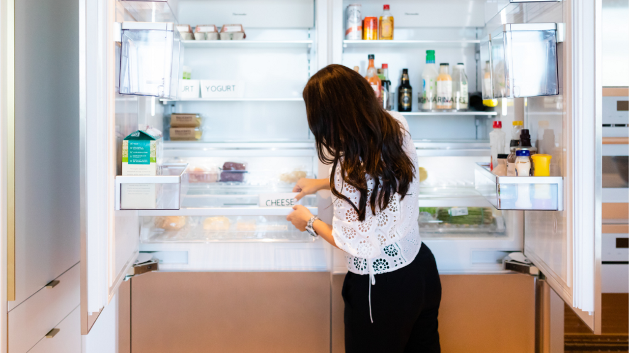 Professional organizer organizing a fridge.