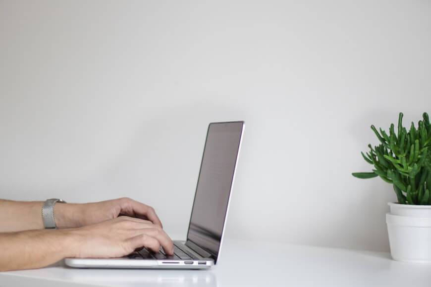 a man types on a laptop