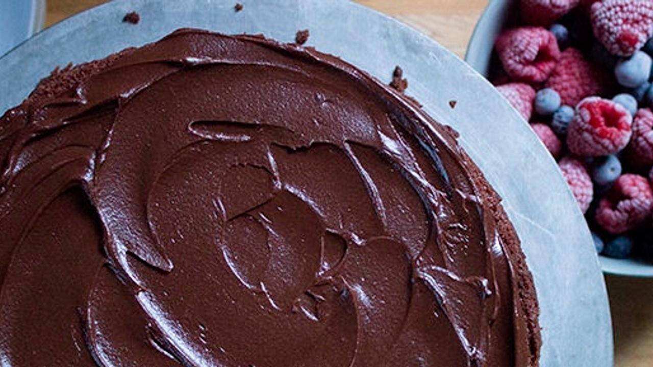 chocolate cake next to a bowl of frozen mixed berries