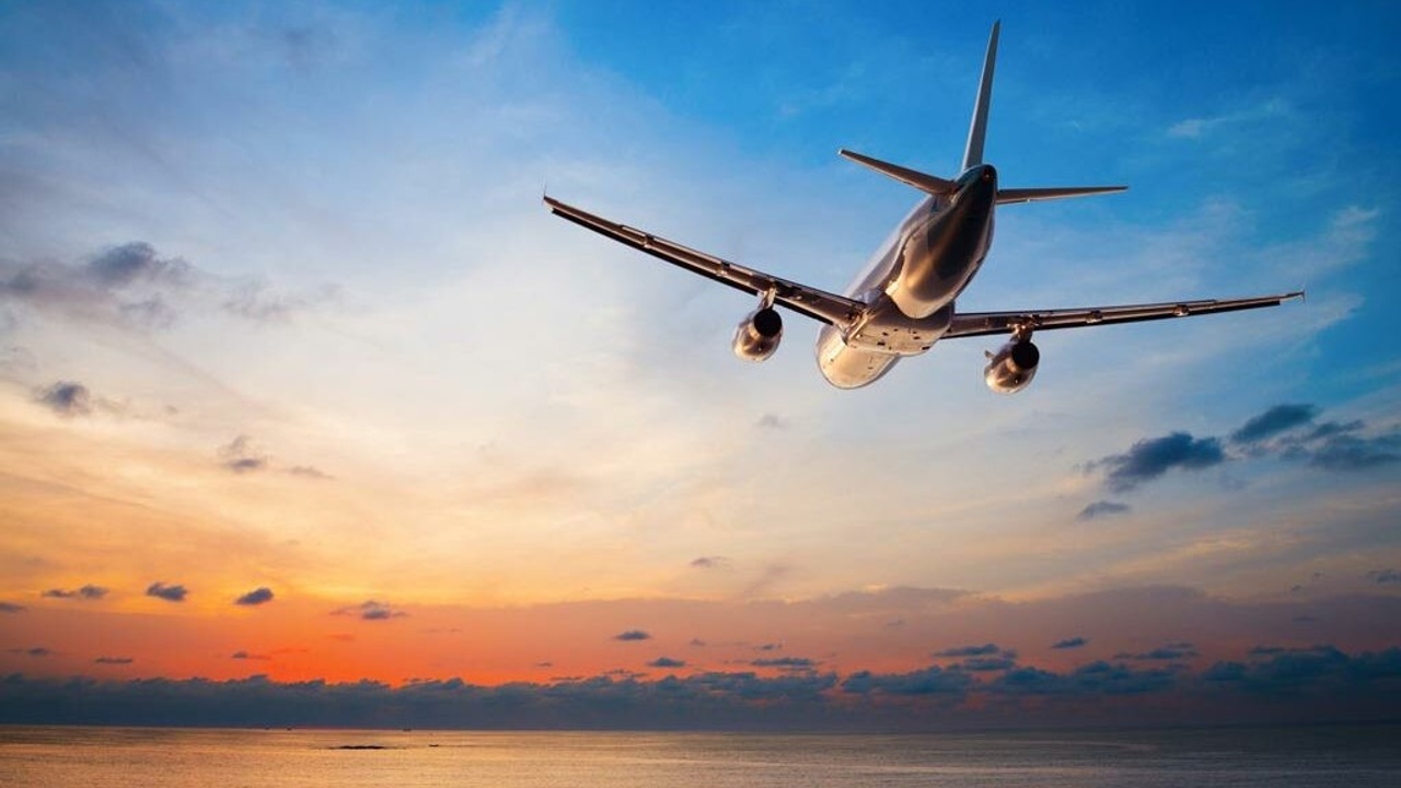 airplane flying in blue and orange sky