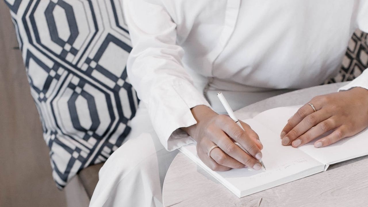 woman sitting in chair writing in notebook