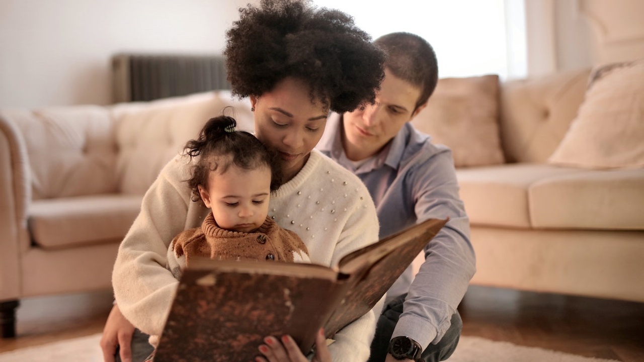 woman and man reading to child