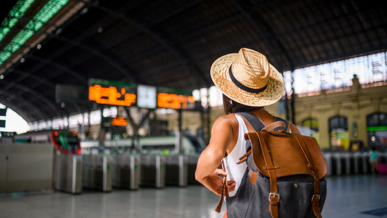 woman wearing a hat and backpack in an airport terminal