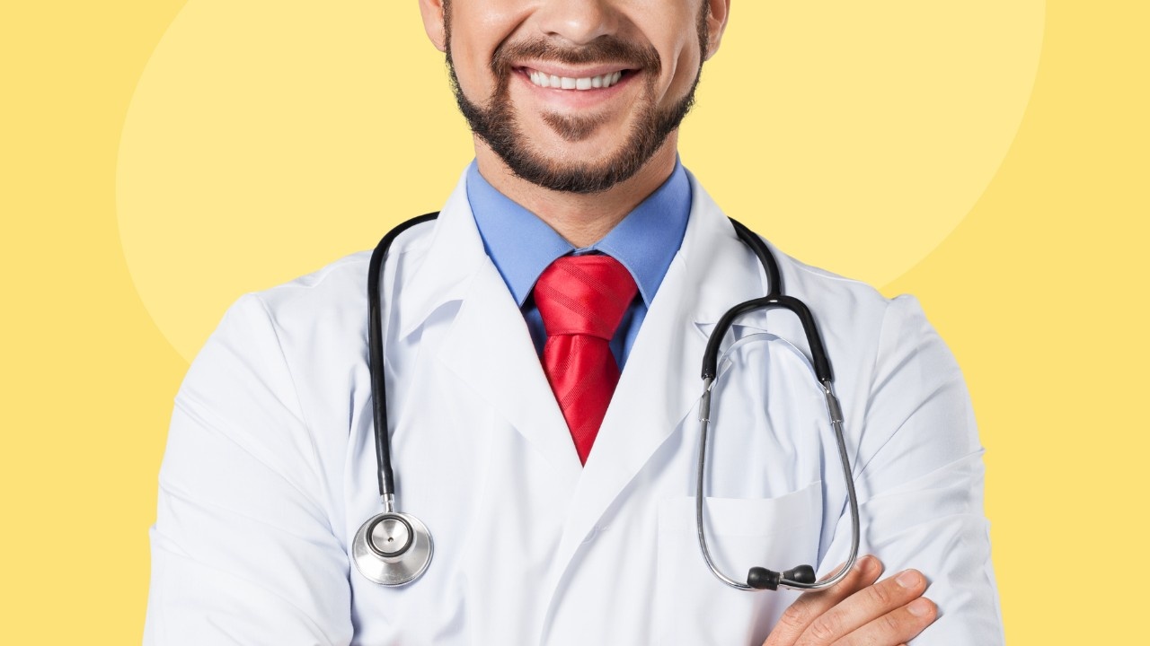 A smiling doctor with a stethoscope around his neck on a yellow background.