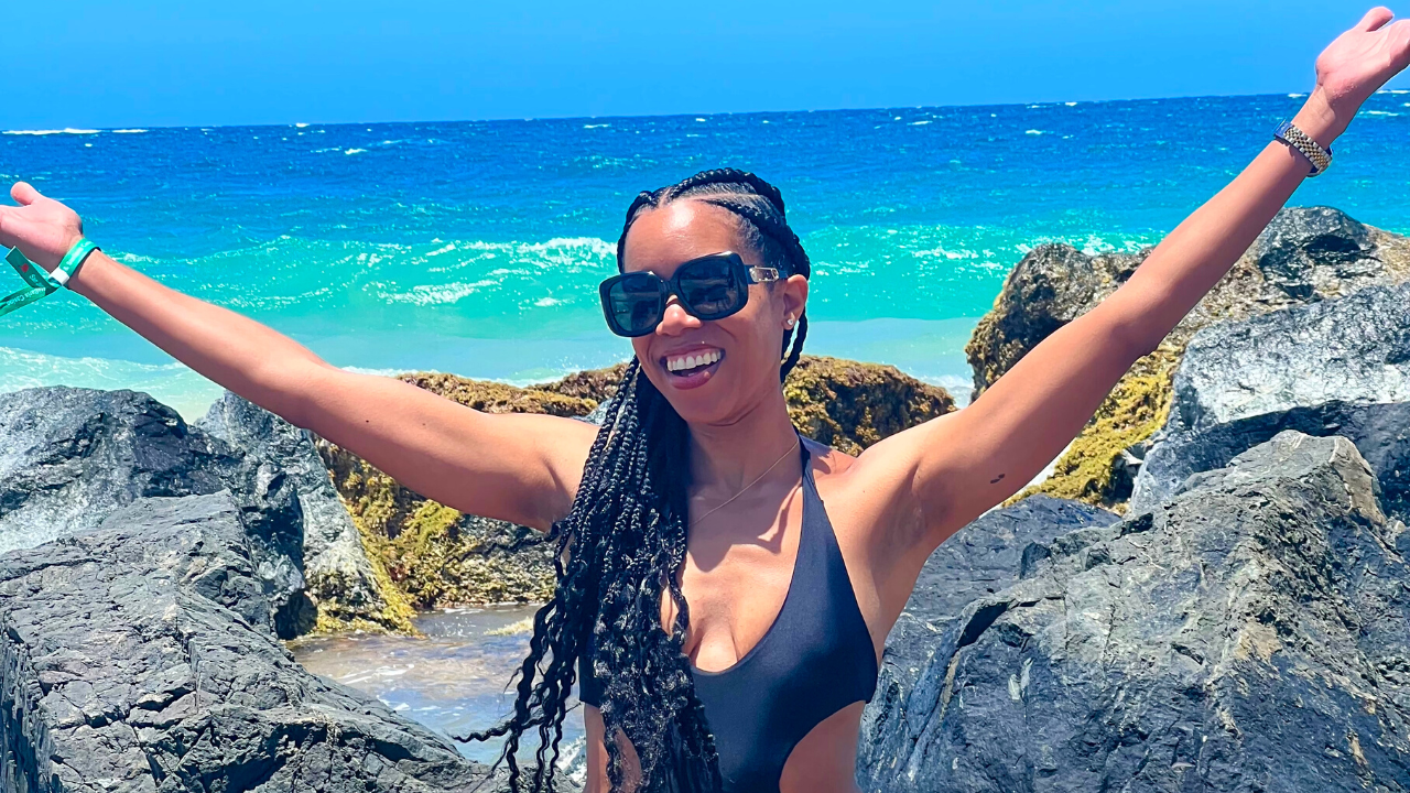 Amber McDuffie sitting on a rock by the ocean in Puerto Rico.