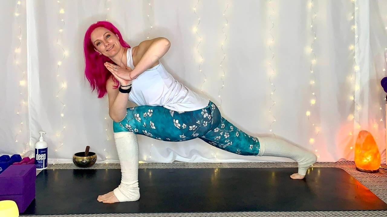 Pink haired woman in twisted crescent lunge yoga pose