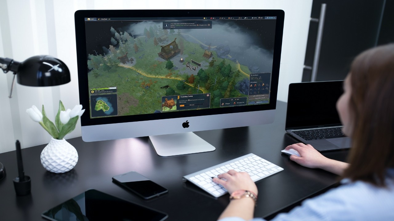Person playing Northgard game, where tips become available contextually.