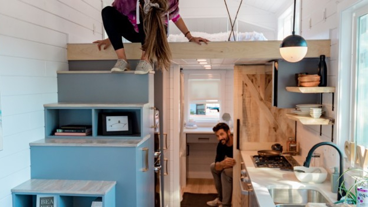 two people smiling in a tiny house