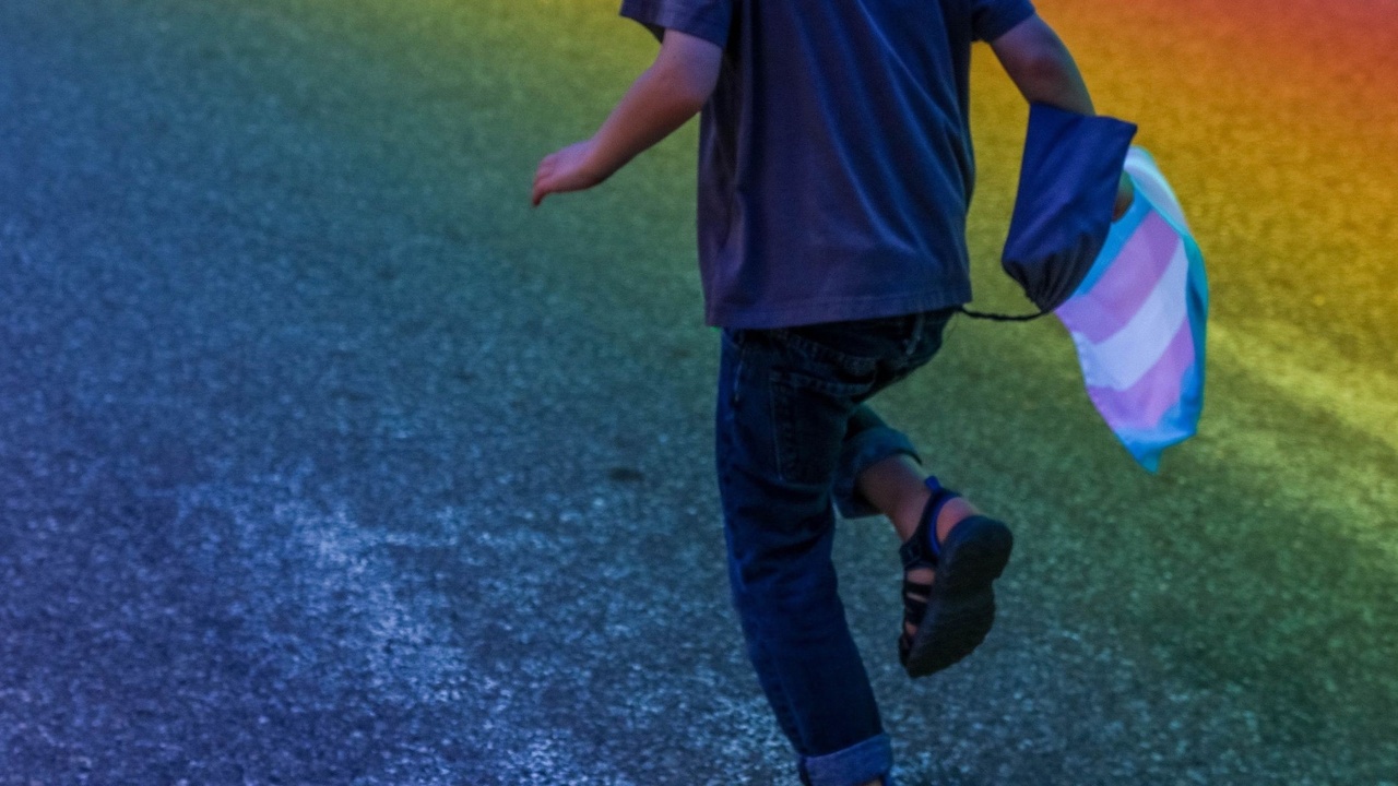 Youth running with trans flag