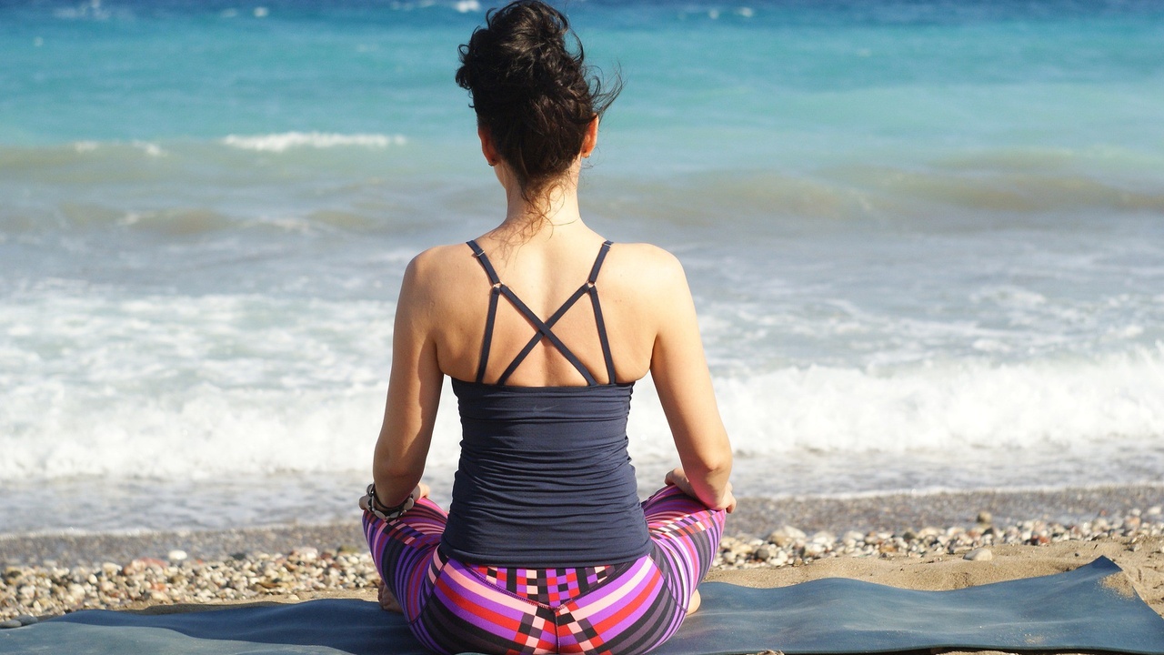 Woman doing Yoga on the beach by Renata Hille of Pixabay