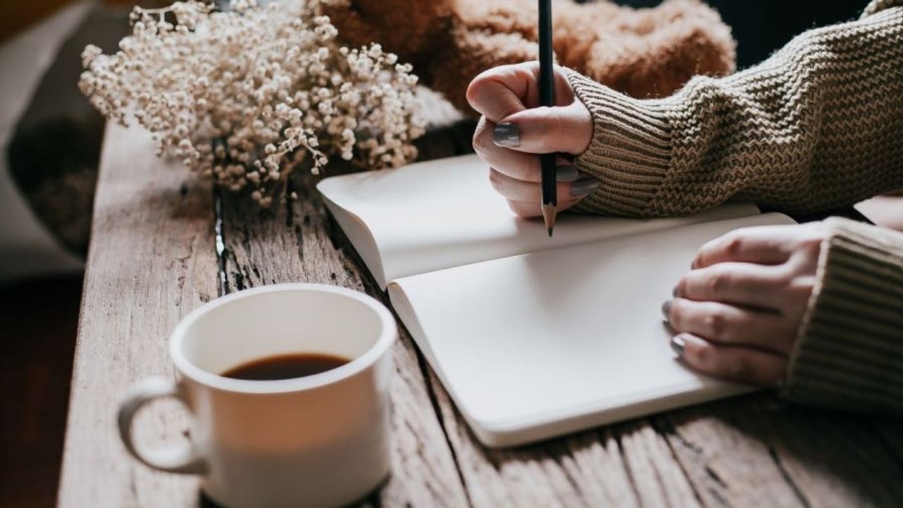 writing a family history in a book with a pen and a cup of coffee