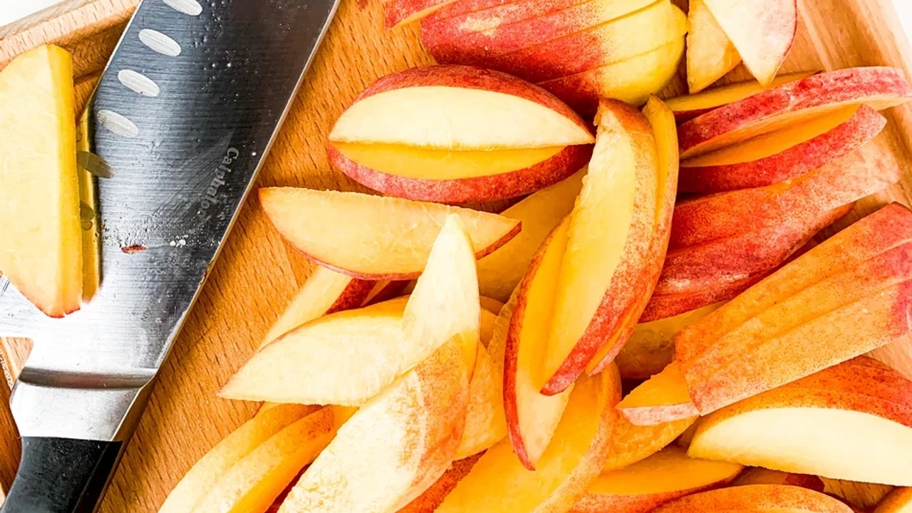 Sliced peaches on a wooden cutting board