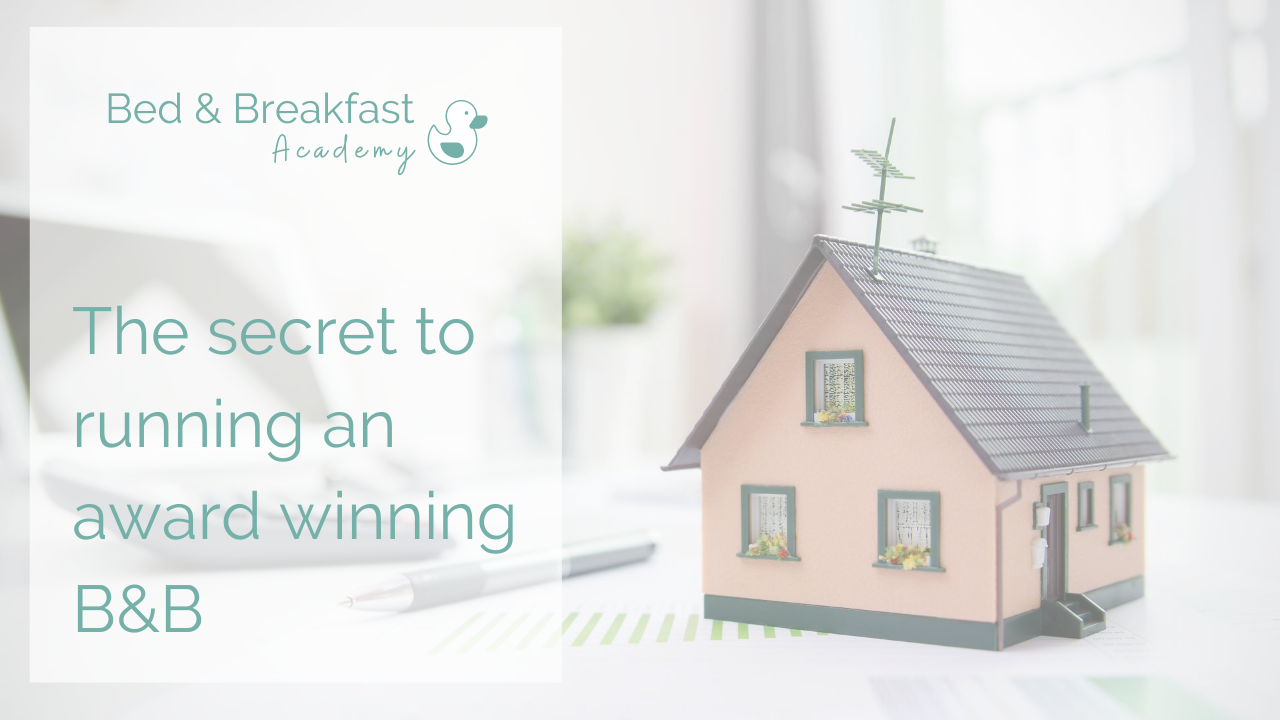 The secret to running an award winning B&B | pink miniature house sitting on a desk 