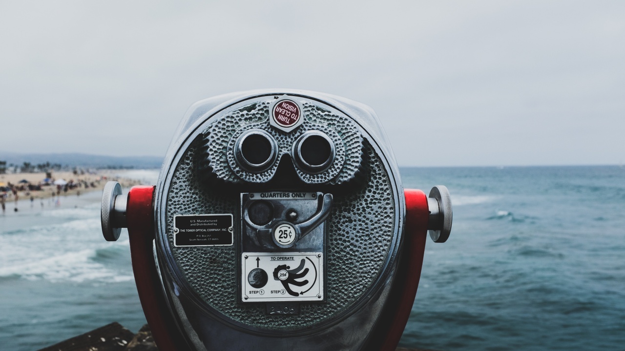 grey and black coin operated telescope viewfinder overlooking ocean