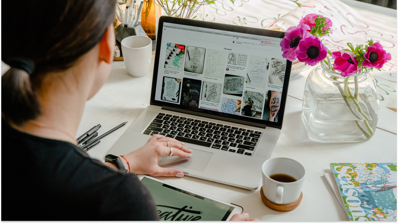 woman working on computer with a cup of coffee on her desk