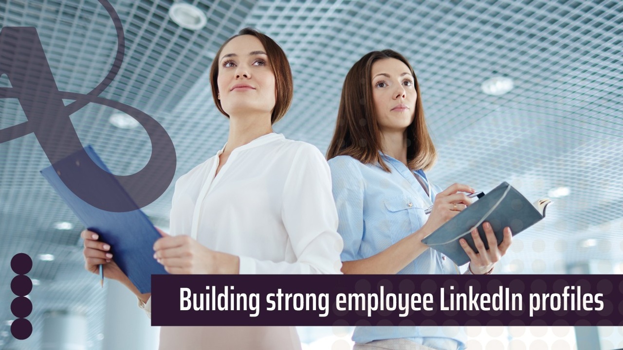 Two women are standing next to each other. They're both holding notebooks and have confident expressions on their faces. The text reads, building strong employee LinkedIn profiles