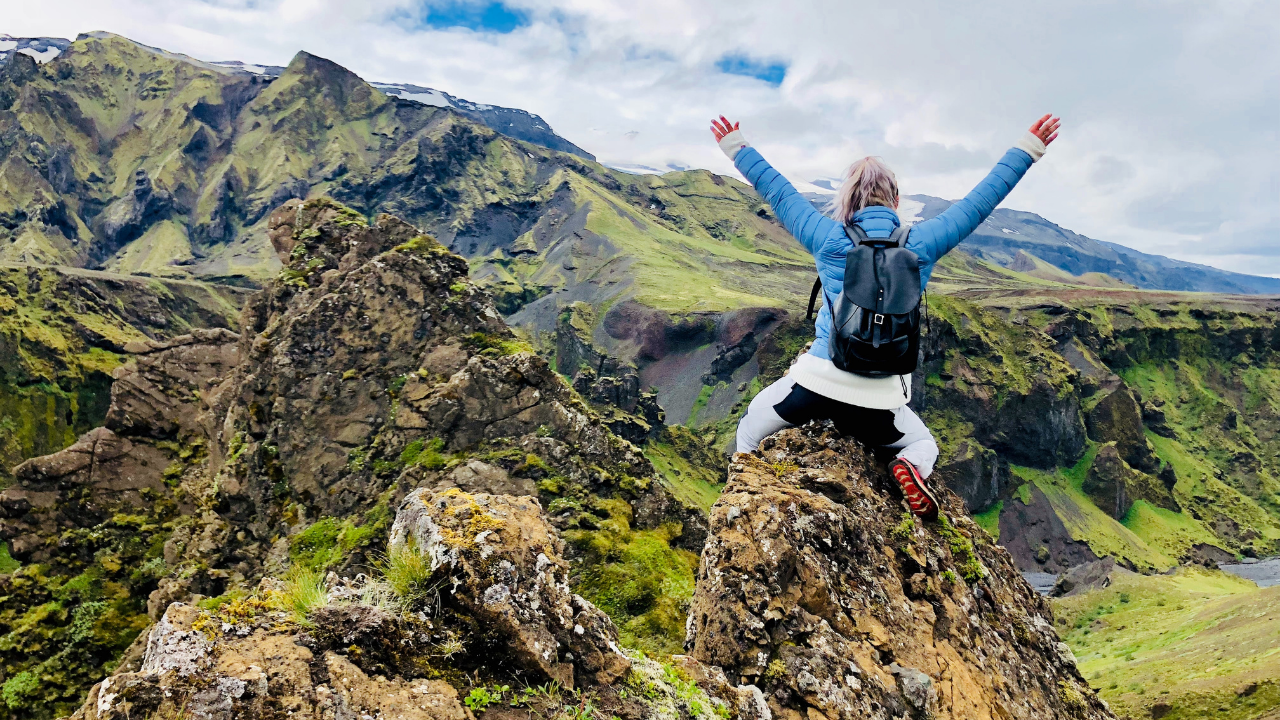 woman celebrating atop a mountain