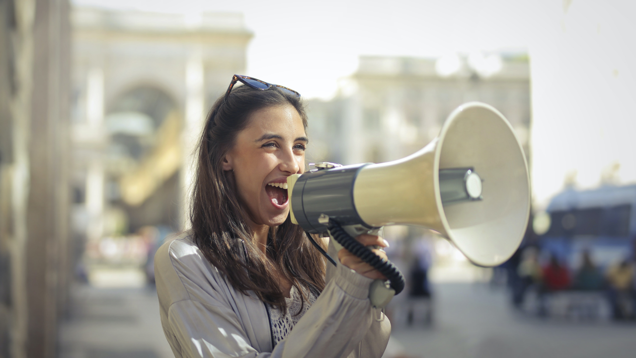 woman announcing the founders society on a loud hailer