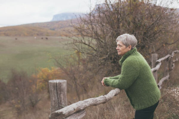 older woman leaning on fence symbolizing boundaries in relationship