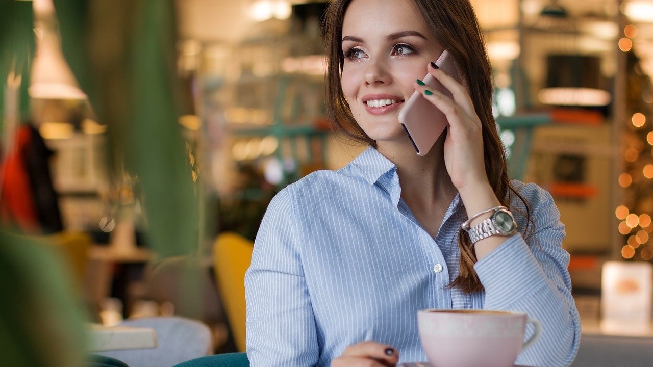 Woman smiling and talking on phone, telling a story