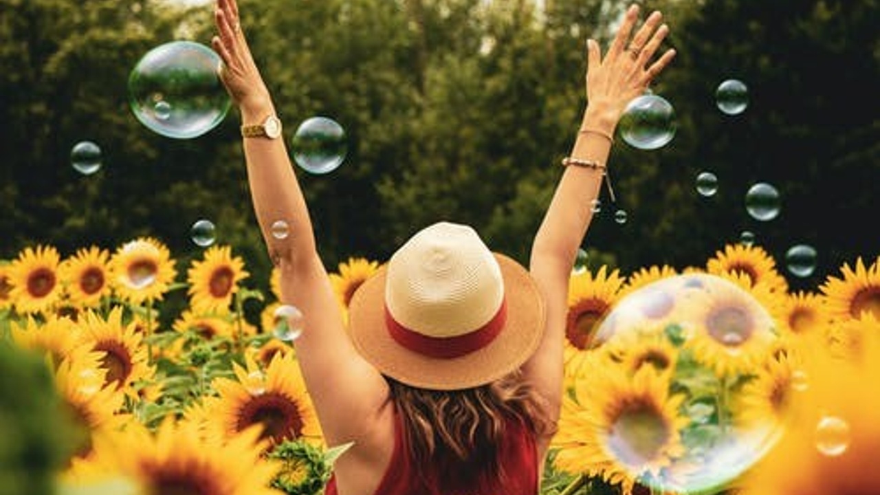 woman dancing between sunflowers