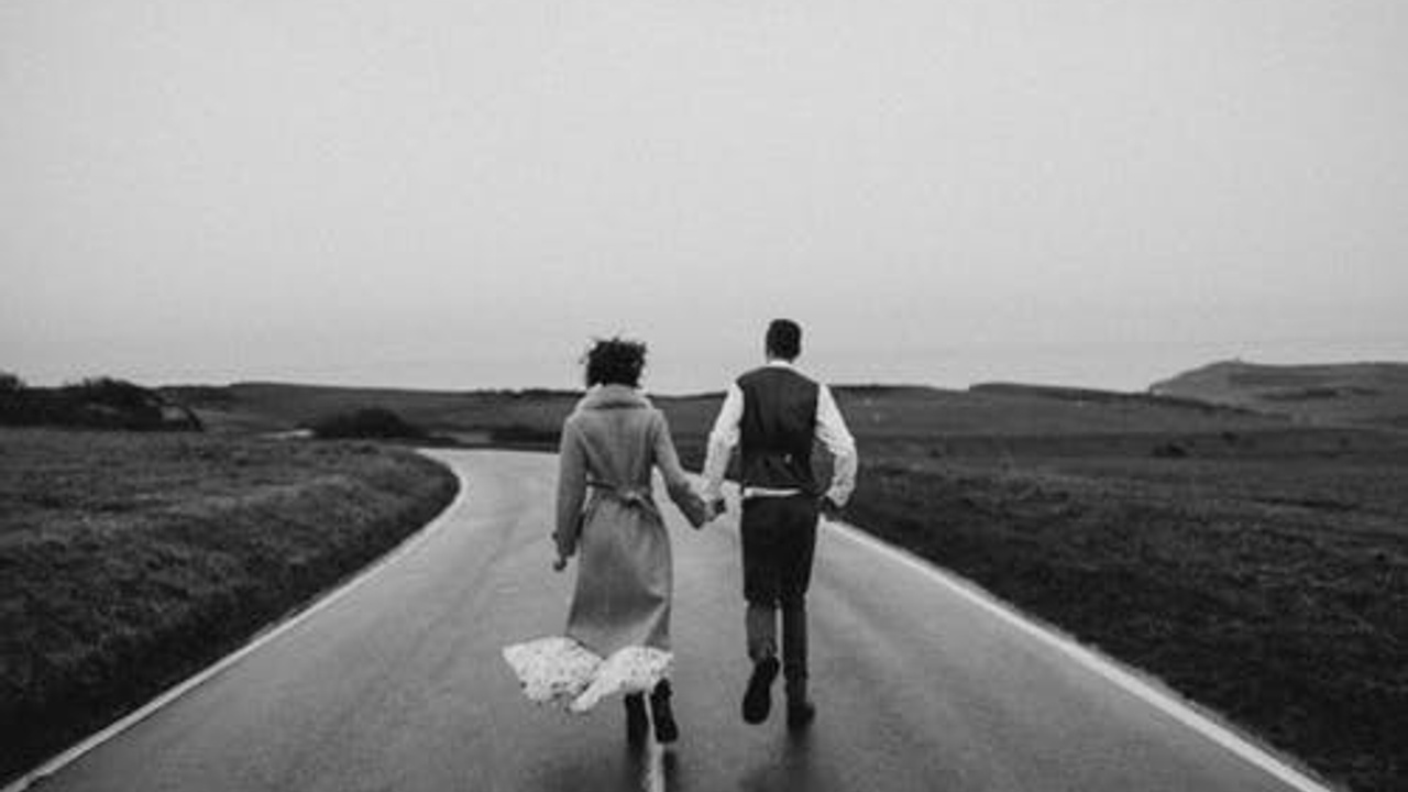 a couple holding hand running on the road