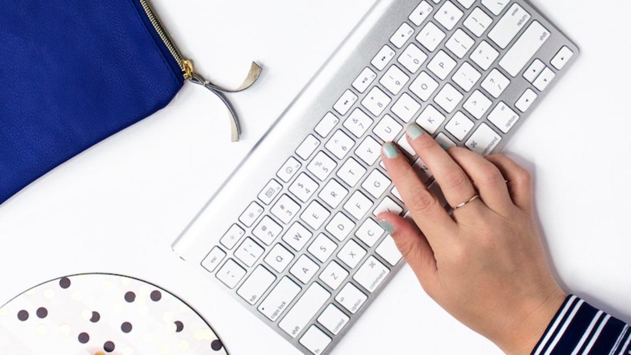 woman's hand on keyboard working on Kajabi