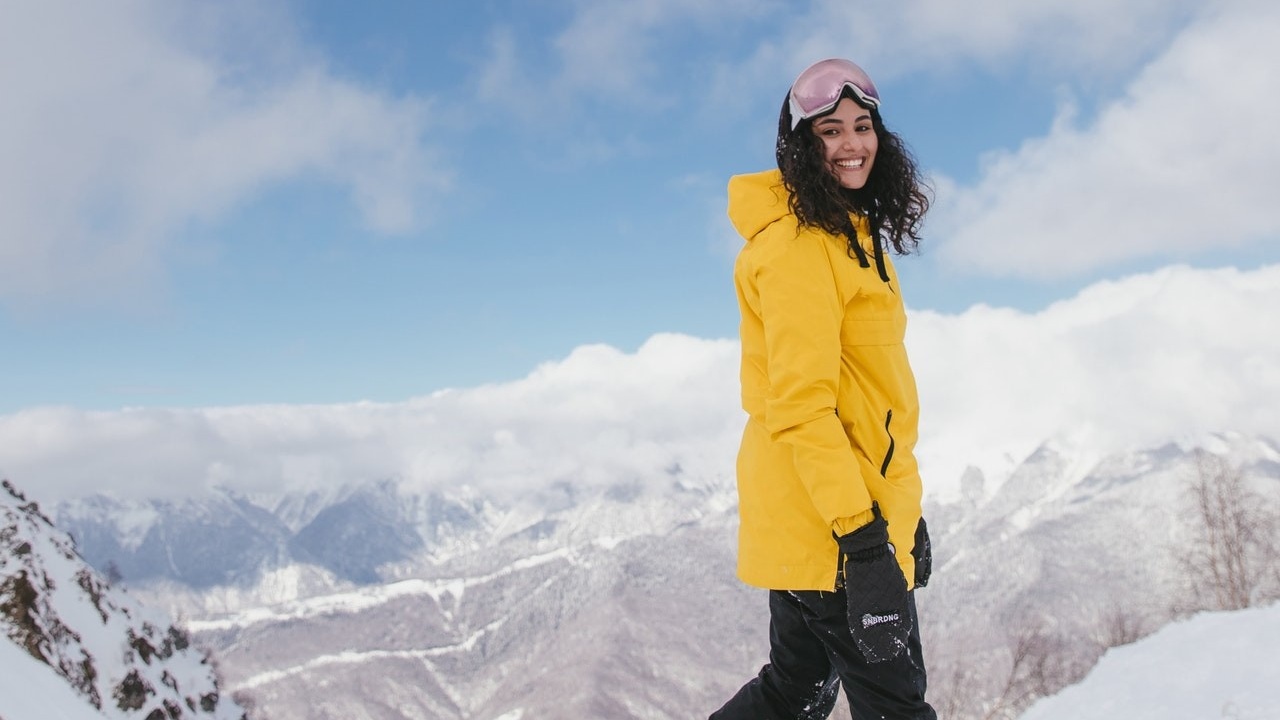 female athlete smiling standing in the snow