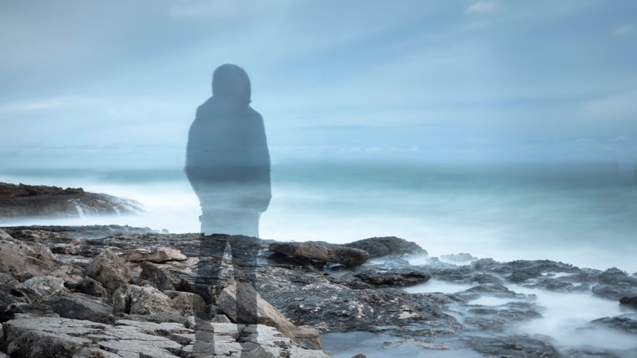 Man standing on edge of rocky shore