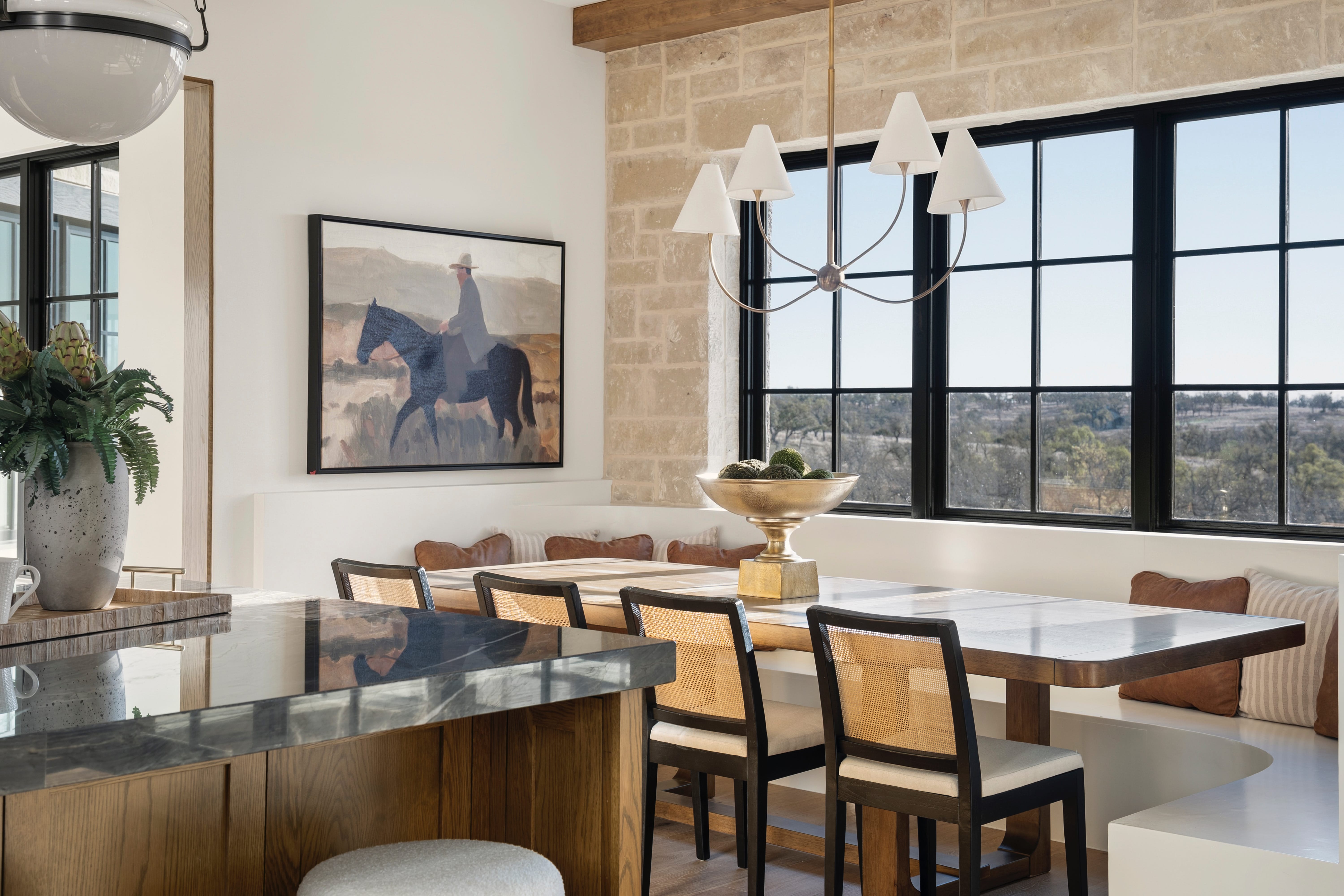 Open-plan dining area with a kitchen island and natural stone walls.