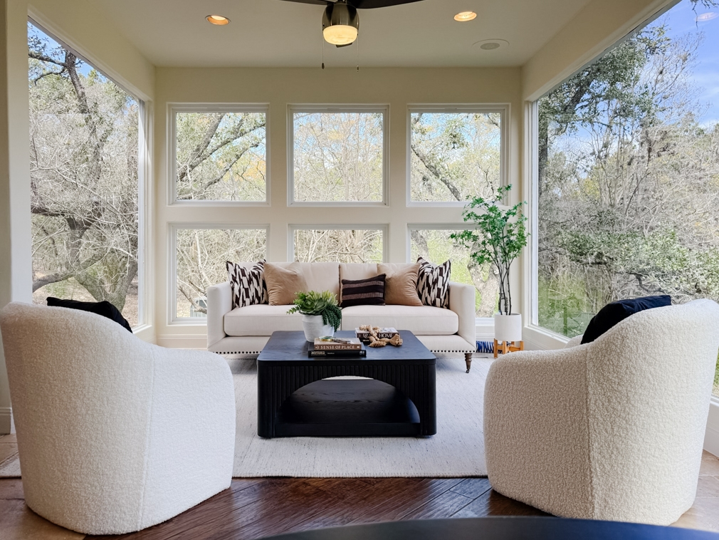 Bright Boerne estate sunroom with windows overlooking a treed landscape.
