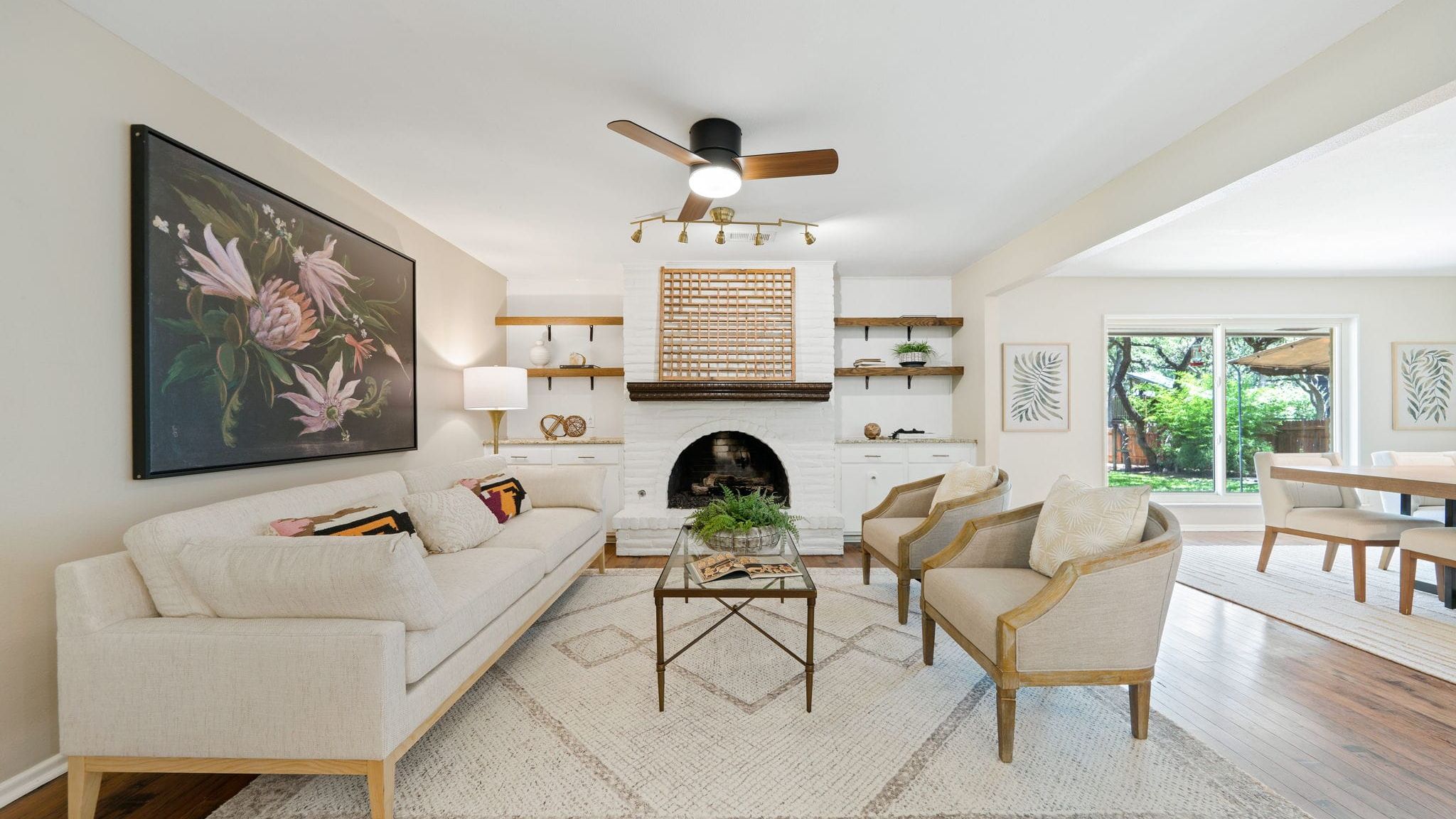 Home staging transformation of a living room with fireplace, neutral furniture, large art, and bright, open design.