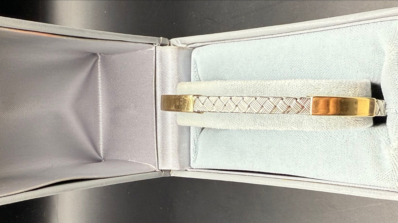 14K white and yellow gold braided rope bracelet with double safety clasp displayed in box.