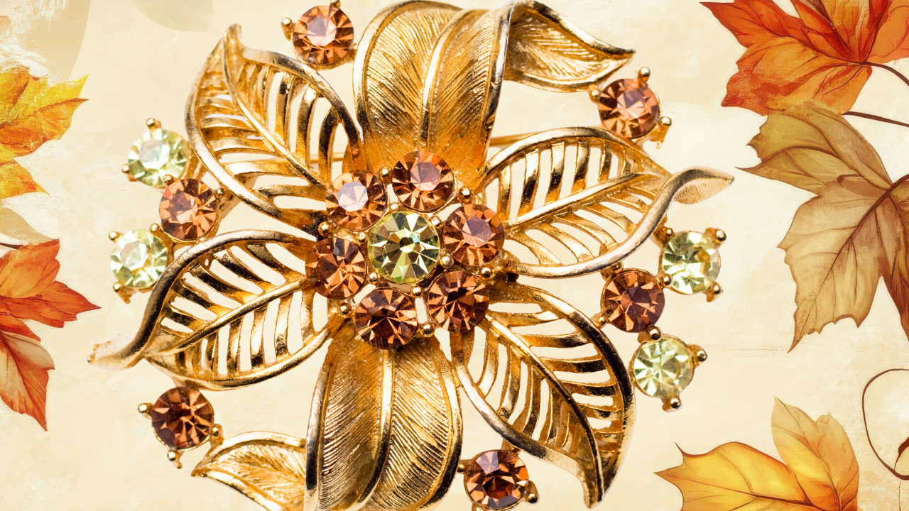 Vintage floral brooch with gold leaves and amber and citrine-colored gemstones, symbolizing collectible fall jewelry style.