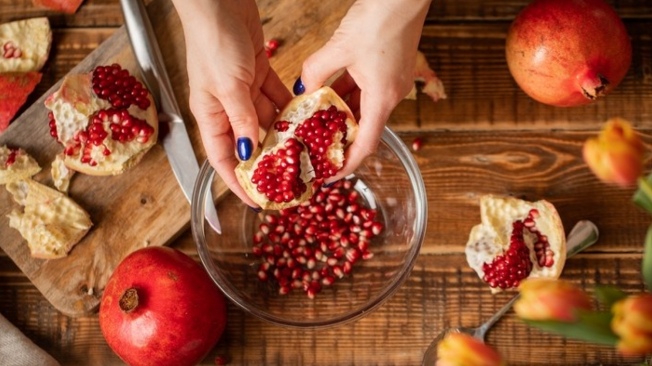 hands deseeding a pomegranate