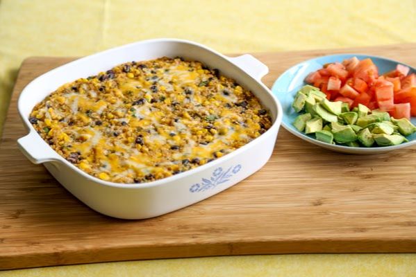 enchilada casserole with avocado and tomato as toppings