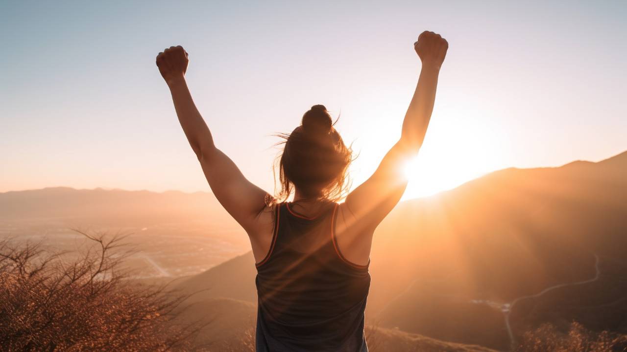 strong motivated woman celebrating goals towards the sun