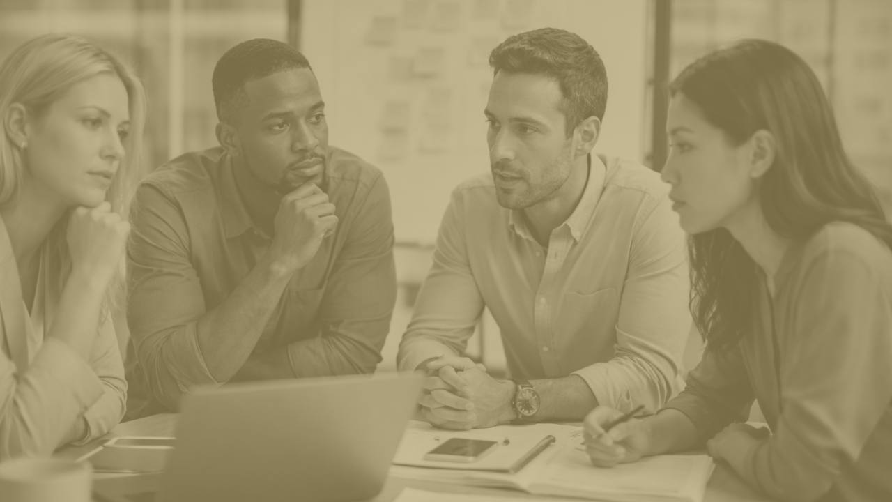 four team members collaboratign around a desk